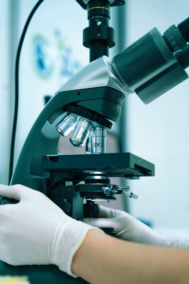 A technologist at the microscope in the Kamini Clinic & Labs laboratory in Jagamara